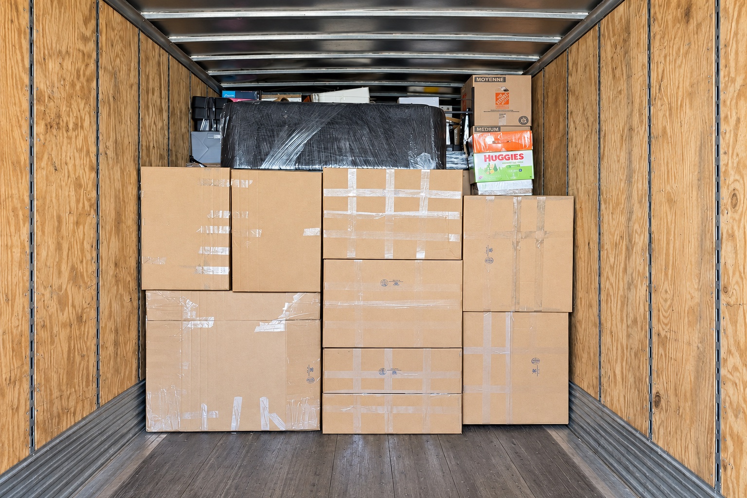 Boxes and wrapped furniture organized inside the moving truck